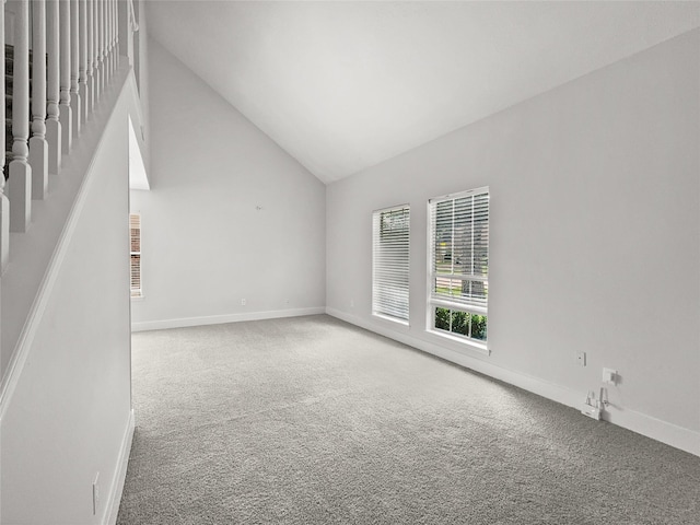 unfurnished living room featuring high vaulted ceiling and carpet floors