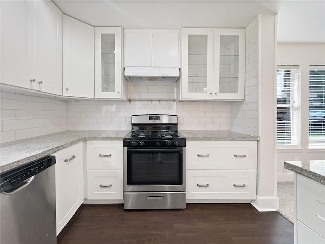 kitchen featuring stainless steel appliances, decorative backsplash, white cabinetry, and light stone countertops