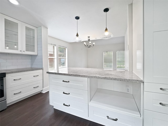 kitchen with white cabinets, decorative light fixtures, backsplash, and light stone counters