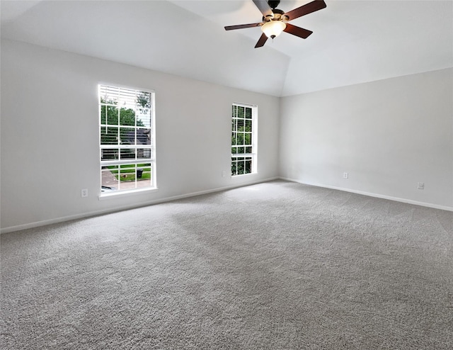 unfurnished room featuring a raised ceiling, carpet floors, ceiling fan, and vaulted ceiling