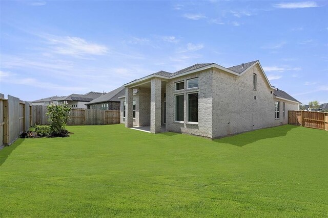 rear view of property featuring a yard