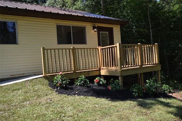 rear view of house featuring a lawn and a wooden deck