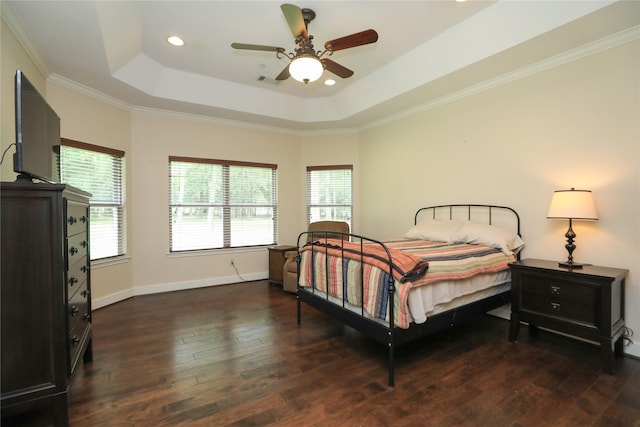 bedroom with a tray ceiling, ceiling fan, dark hardwood / wood-style flooring, and crown molding