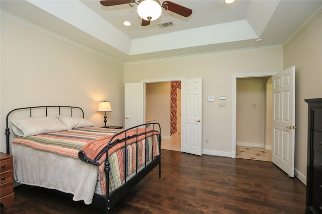 bedroom with a raised ceiling, ceiling fan, crown molding, and dark wood-type flooring