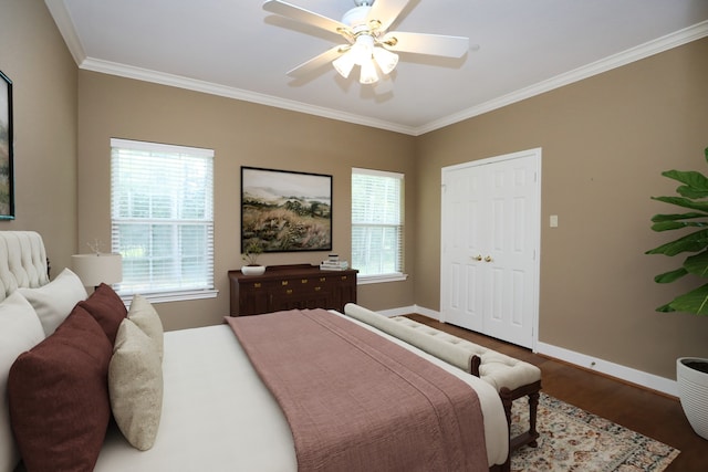 bedroom with a closet, dark hardwood / wood-style floors, ceiling fan, and ornamental molding