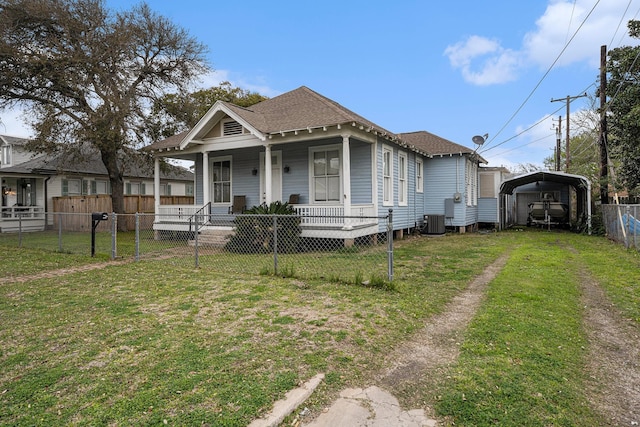 bungalow-style house with central air condition unit, covered porch, a front yard, and a carport