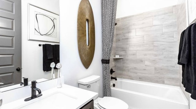 full bathroom with tiled shower / bath combo, vanity, and toilet