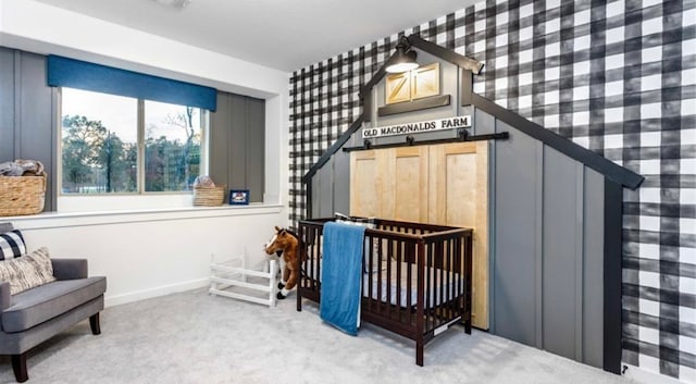 carpeted bedroom featuring a nursery area