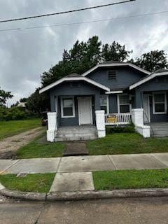 view of front of property with a porch and a front lawn