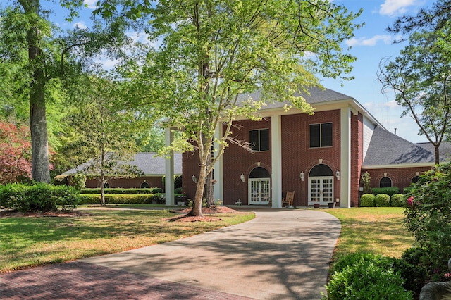 view of front of home with a front yard and french doors