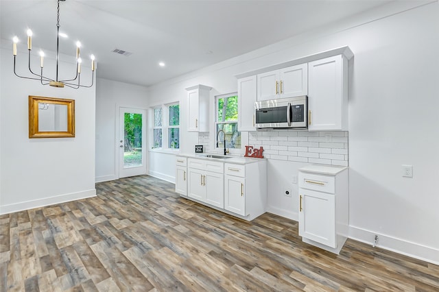 kitchen featuring a healthy amount of sunlight, hardwood / wood-style floors, white cabinetry, and sink