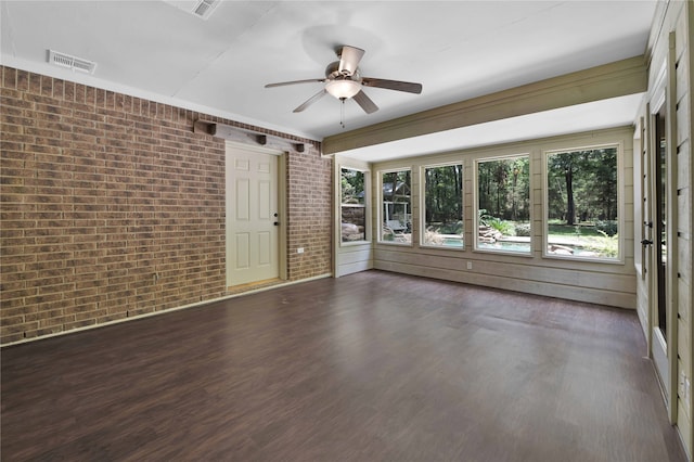 empty room featuring ceiling fan, dark wood-type flooring, and brick wall