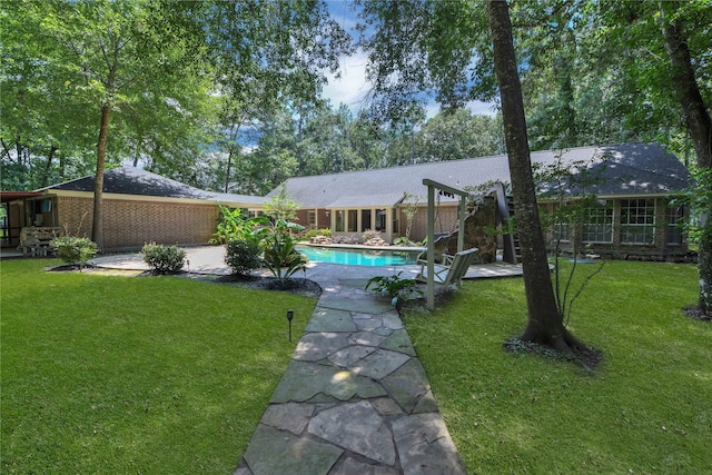 back of property with a yard and a patio