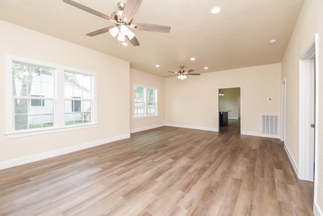 empty room with ceiling fan and light wood-type flooring