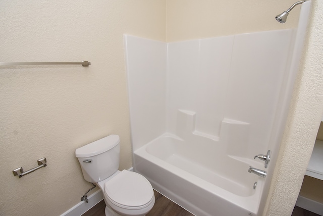 bathroom featuring wood-type flooring, toilet, and shower / bathtub combination