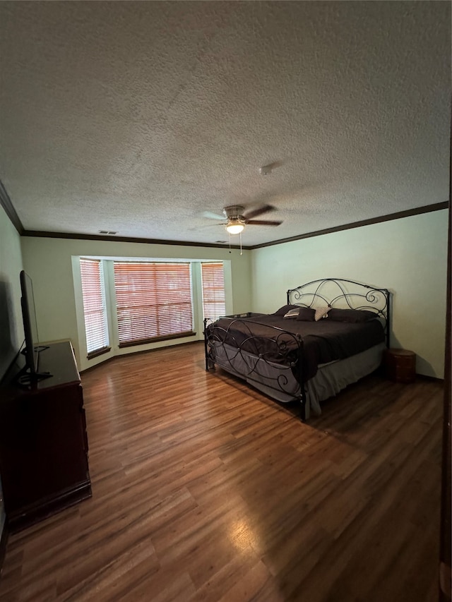 bedroom with a textured ceiling, ceiling fan, hardwood / wood-style floors, and crown molding