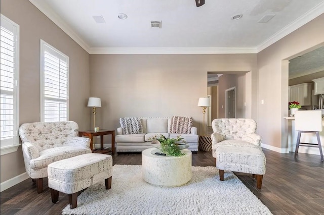 living room featuring baseboards, crown molding, visible vents, and wood finished floors