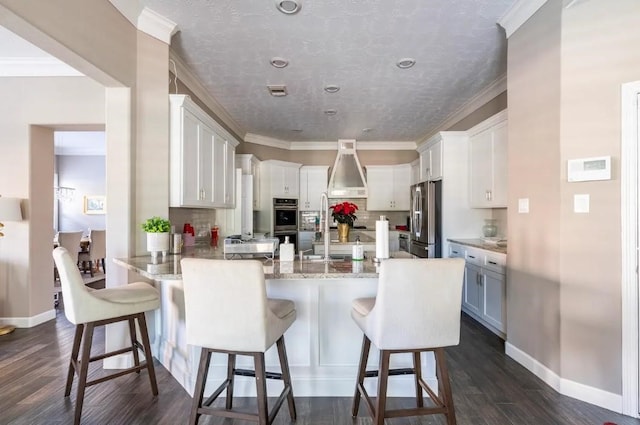 kitchen featuring a peninsula, dark wood-style flooring, stainless steel appliances, and crown molding