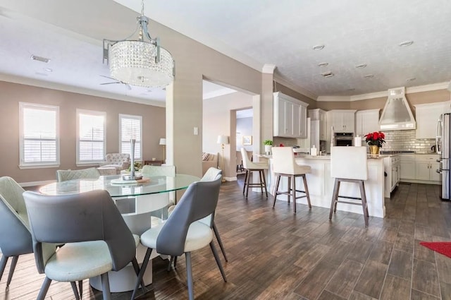 dining room featuring dark wood-style floors, visible vents, crown molding, and an inviting chandelier