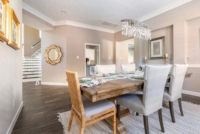 dining room featuring a notable chandelier, crown molding, baseboards, and wood finished floors