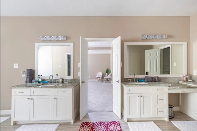 bathroom with wood finished floors, vanity, and baseboards