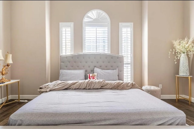 bedroom with dark wood-style flooring and baseboards