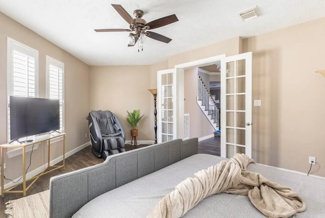 bedroom with french doors, visible vents, baseboards, and wood finished floors