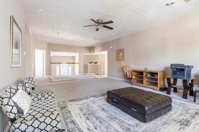 carpeted living room featuring ceiling fan and baseboards