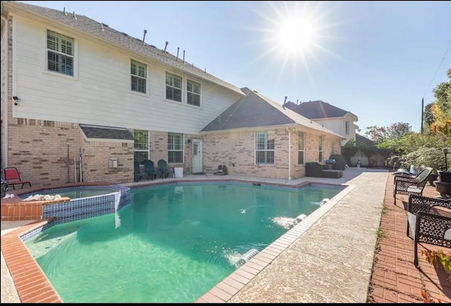 view of pool featuring a pool with connected hot tub, a patio, and fence