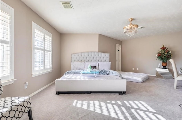 bedroom with a chandelier, carpet flooring, visible vents, and baseboards