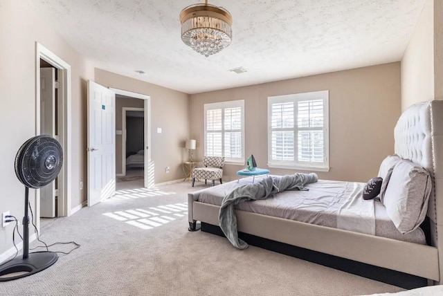 carpeted bedroom with visible vents, baseboards, and a textured ceiling