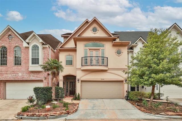 view of front facade featuring a balcony, stucco siding, concrete driveway, and french doors