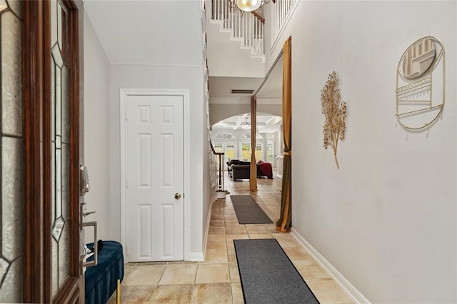 hall with crown molding and light tile flooring