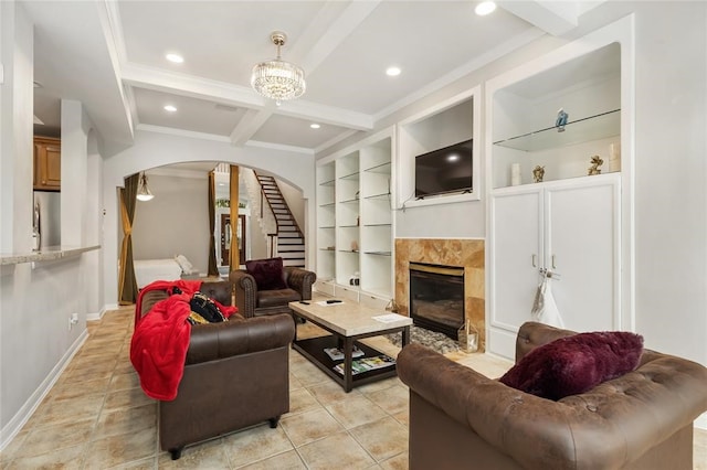 living room featuring light tile floors, built in shelves, beamed ceiling, and a fireplace