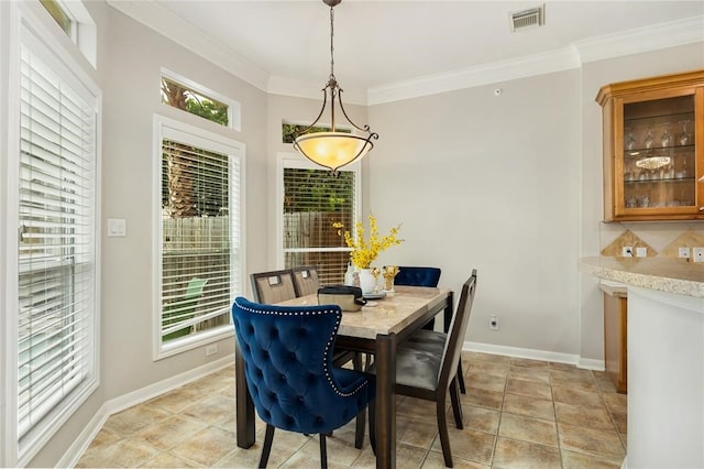 tiled dining room featuring crown molding