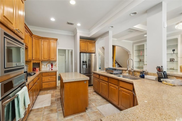 kitchen with visible vents, brown cabinetry, appliances with stainless steel finishes, ornamental molding, and a sink