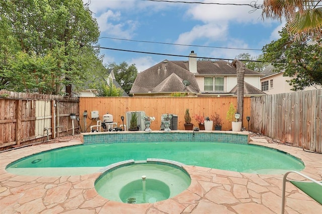 view of swimming pool with a pool with connected hot tub and a fenced backyard