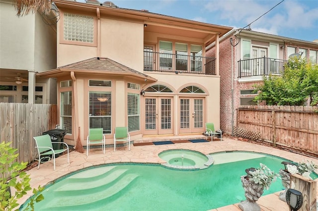 back of property with a patio area, a balcony, and a pool with hot tub