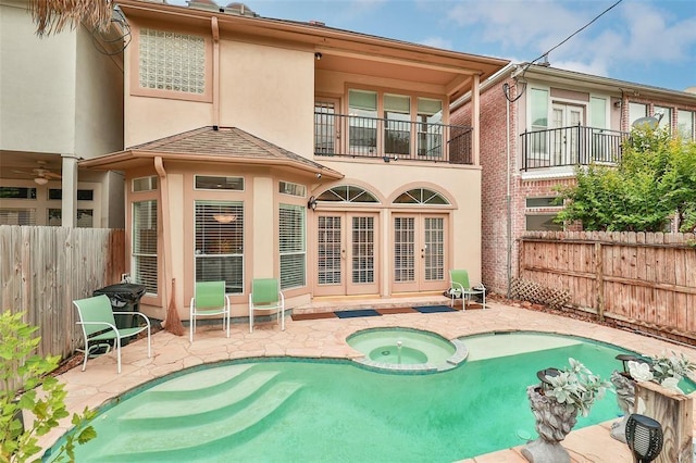 rear view of property featuring a fenced backyard, an in ground hot tub, french doors, a patio area, and stucco siding