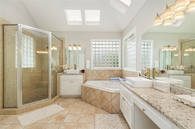 bathroom with vaulted ceiling with skylight, tile patterned flooring, a shower stall, and a bath