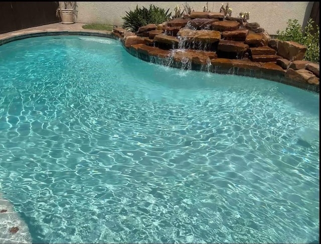 view of swimming pool featuring pool water feature