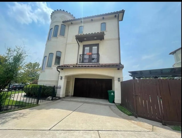 mediterranean / spanish-style home featuring a garage and a balcony