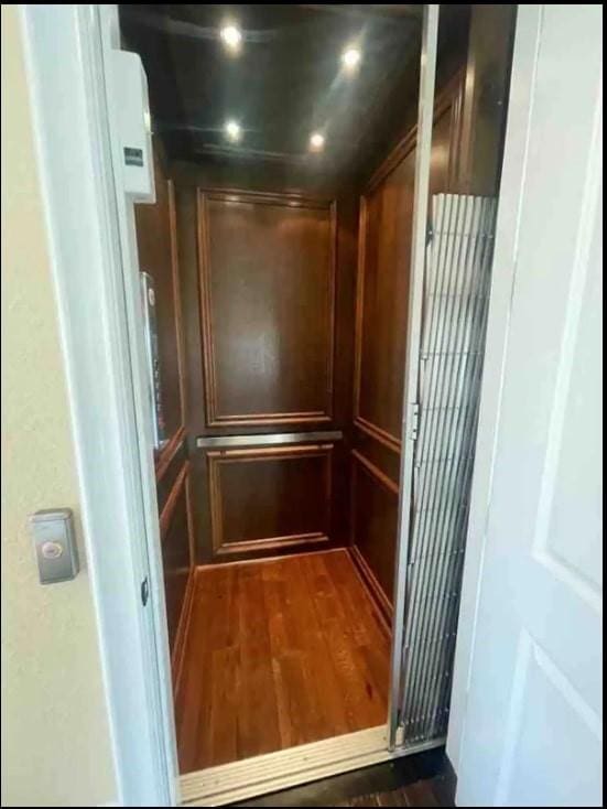 room details with elevator and hardwood / wood-style flooring