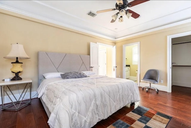 bedroom featuring ensuite bathroom, a raised ceiling, ceiling fan, crown molding, and dark hardwood / wood-style floors