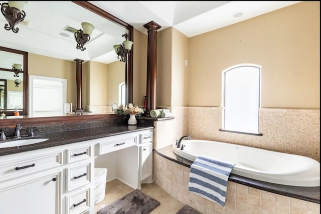 bathroom with tiled bath, tile patterned flooring, and vanity