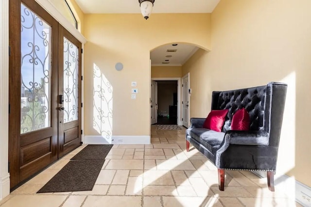 foyer entrance featuring french doors and ornamental molding