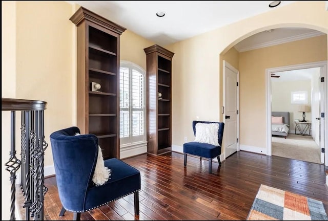 living area with dark hardwood / wood-style floors and ornamental molding