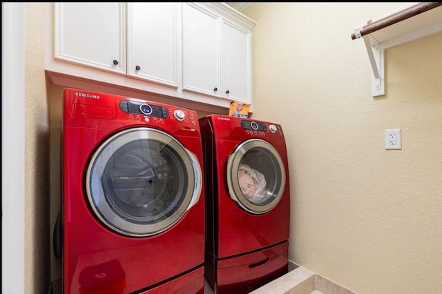 washroom with cabinets and washer and dryer