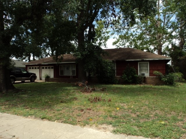 ranch-style house with a garage and a front lawn