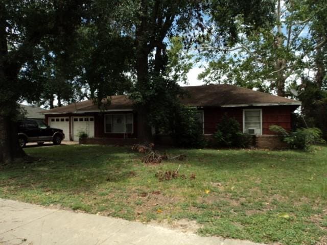 ranch-style home with a garage and a front lawn